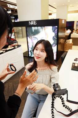 지난 4일 서울 압구정동 갤러리아백화점 명품관 내 색조화장품 브랜드인 '나스' 매장에서 인플루언서 상아튜브가 촬영하는 모습. <한화갤러리아 제공>